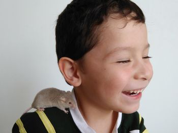 Close-up of cute boy against white background