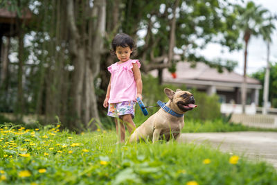 Girl standing with dog at park