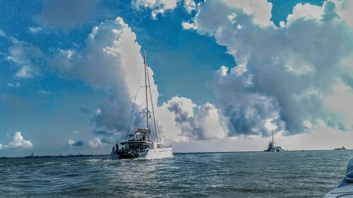 Sailboats sailing in sea against sky