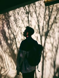 Low angle view of silhouette man standing on tree against sky