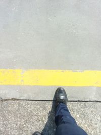 Low section of man standing on road