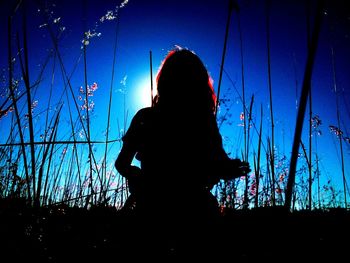 Rear view of silhouette woman against clear blue sky