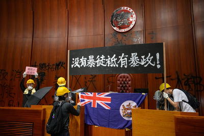 Rear view of people standing against graffiti