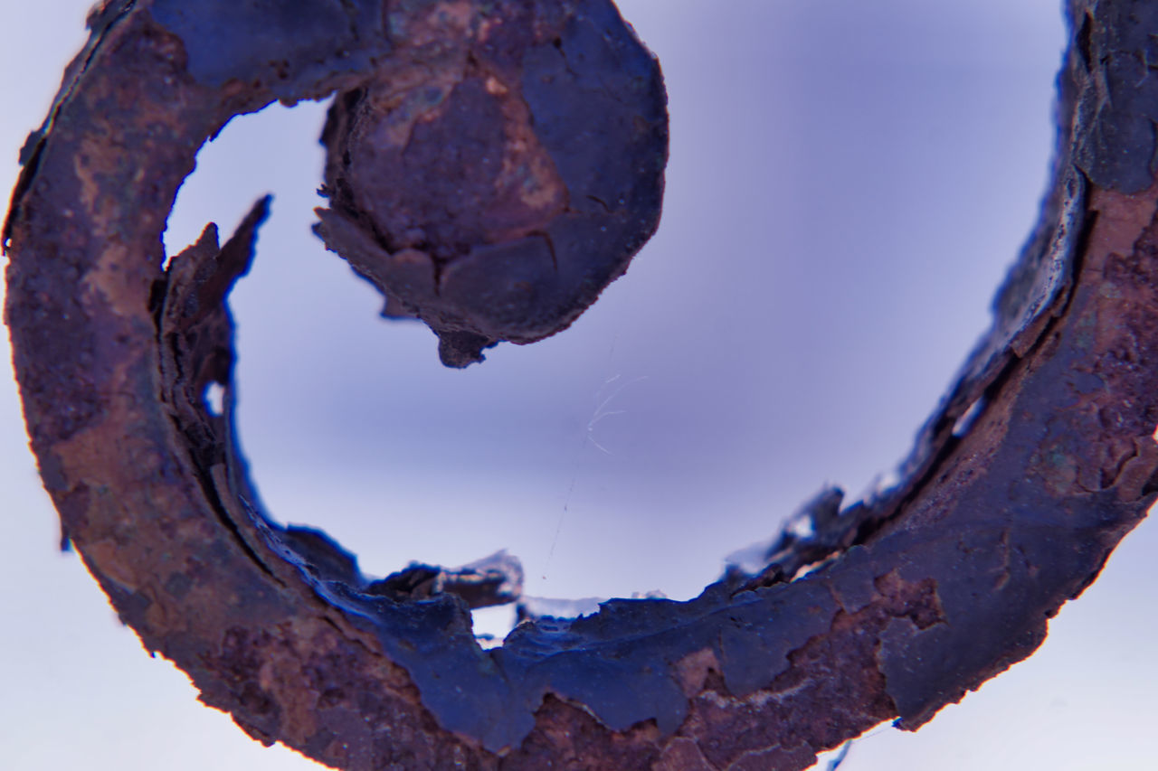 CLOSE-UP OF SNOW ON RUSTY METAL AGAINST SKY