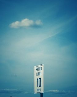 Road sign against sky