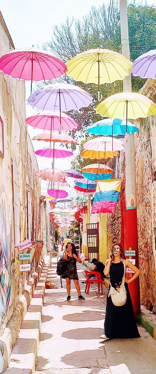 protection, real people, umbrella, adult, women, lifestyles, security, architecture, people, day, leisure activity, group of people, men, parasol, built structure, full length, outdoors, nature, multi colored