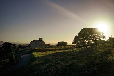 Built structure on field against sky at sunset