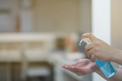 Close-up of hand holding cigarette against blurred background