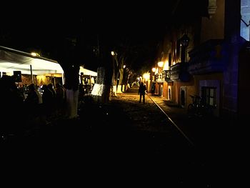 Woman standing in illuminated city at night