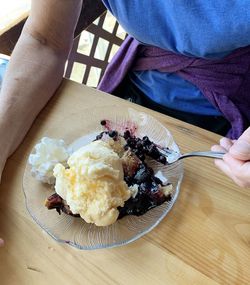 Midsection of person holding ice cream in plate