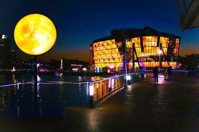 Illuminated buildings against sky at night