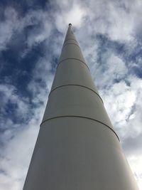 Low angle view of communications tower against cloudy sky