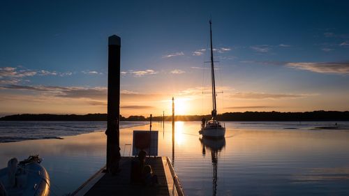 Silhouette ship on sea against sky during sunset