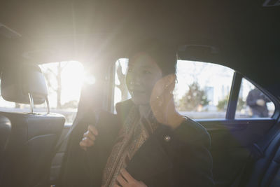 Young asian businesswoman sitting in car service limousine