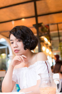 Portrait of a young woman sitting in restaurant