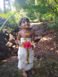 Portrait of smiling girl standing against plants