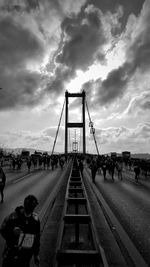 People on bridge against sky