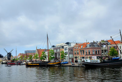 Sailboats moored in river against sky