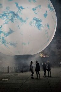 Group of people walking on road against sky