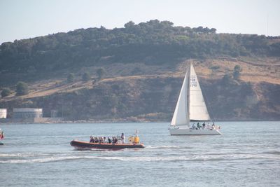 Sailboat sailing on river against sky