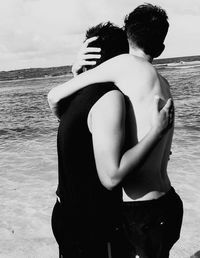 Rear view of couple kissing at beach