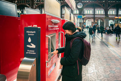 Smiling student girl near vending machines in the  copenhagen central railway station. denmark