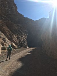 Rear view of man standing on mountain against sky