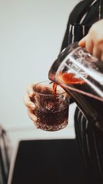 Close-up of hand pouring drink in glass
