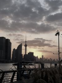 Modern buildings in city against sky during sunset