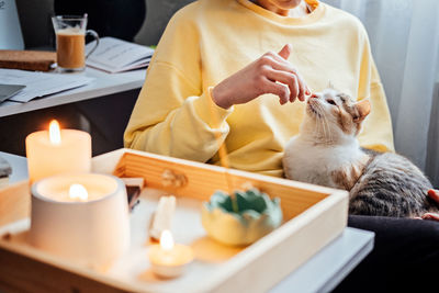 Mental health, mindfulness, wellbeing. faceless portrait of relaxed young woman with cat sitting