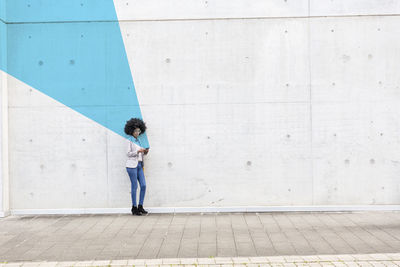 Full length of woman standing on footpath