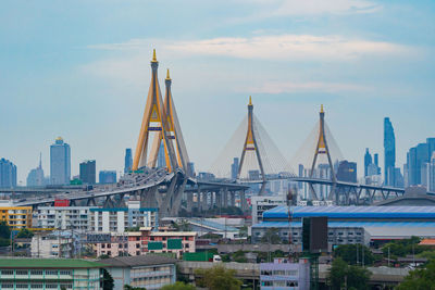 Sailboats in harbor by buildings against sky in city