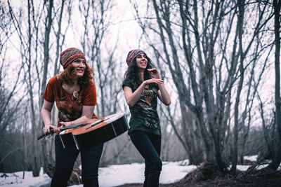 Full length of smiling young woman in winter