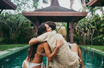 Rear view of woman with arms raised in water