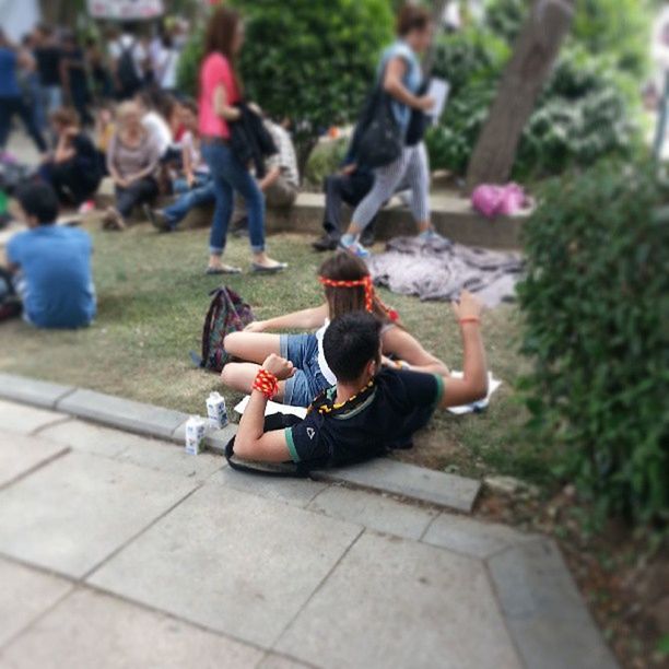 lifestyles, leisure activity, person, casual clothing, full length, sitting, park - man made space, focus on foreground, childhood, men, day, outdoors, rear view, girls, tree, incidental people, enjoyment
