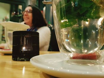 Woman sitting at glass table in restaurant
