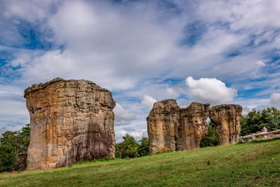 View of stone wall on field against cloudy sky