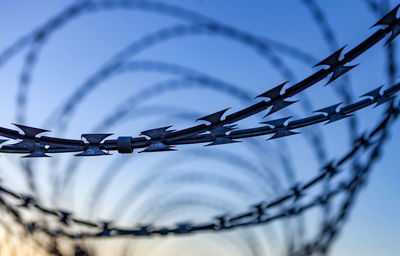 Low angle view of barbed wire against sky