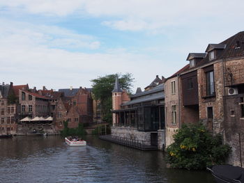 River amidst buildings in city against sky