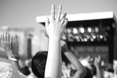 Close-up of woman hand against people at music concert