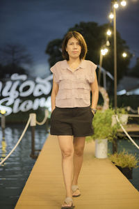 Portrait of young woman standing on railing