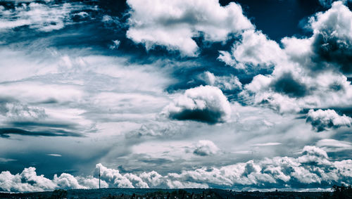 Snow covered landscape against cloudy sky