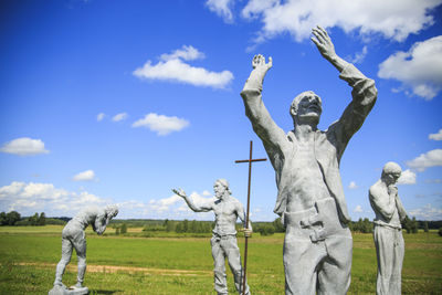 Low angle view of statue on field against sky