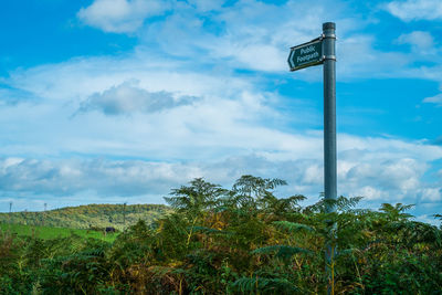 Low angle view of cross on pole against sky