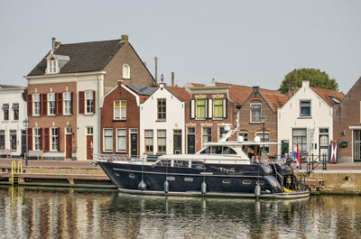 Houses by canal against sky