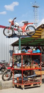 Stack of bicycle on metal against sky