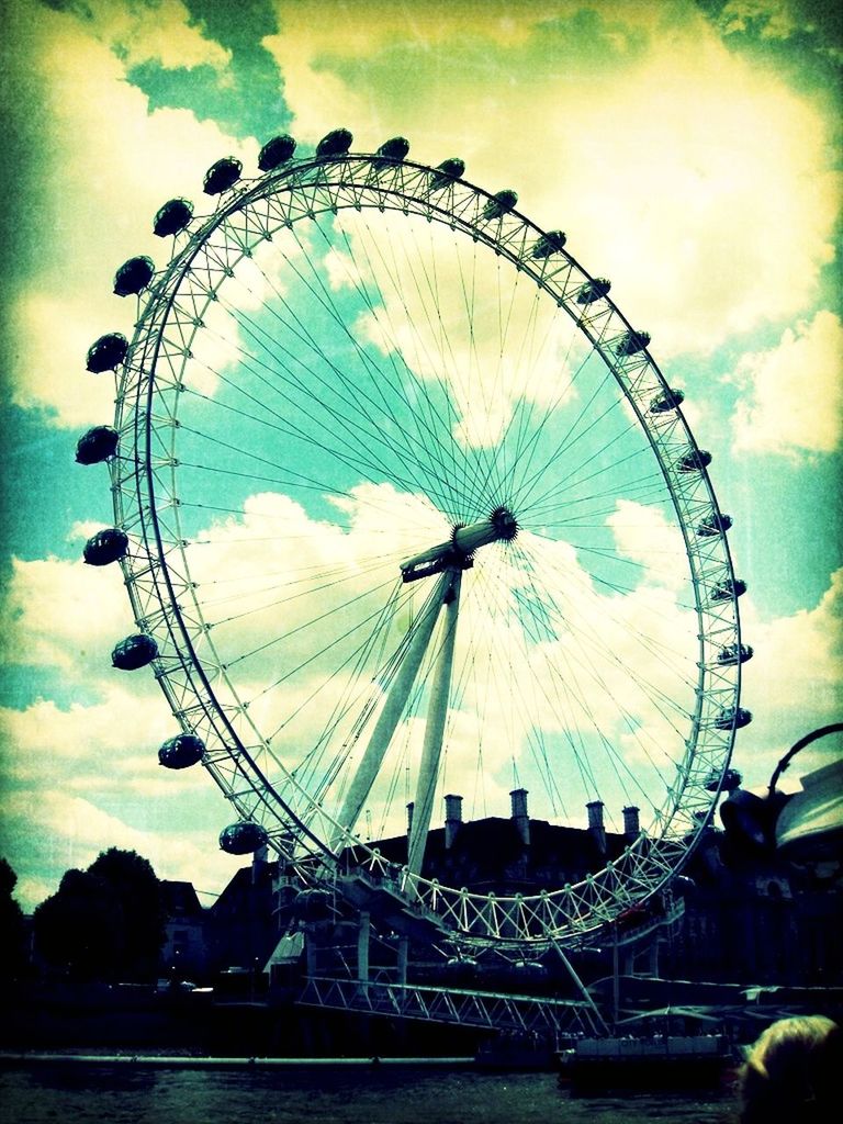 ferris wheel, amusement park, amusement park ride, arts culture and entertainment, sky, circle, cloud - sky, low angle view, built structure, big wheel, fun, cloudy, architecture, cloud, outdoors, large, leisure activity, incidental people, fairground, travel destinations