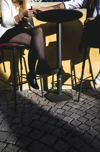 Low section of woman sitting on table at sidewalk cafe