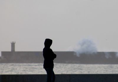 Side view of silhouette person standing by river