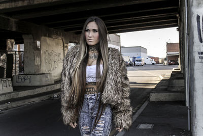 Portrait of young woman standing in city